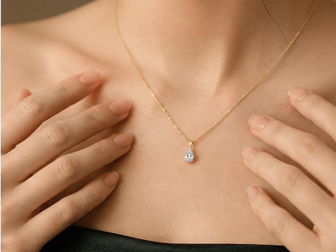 Pear-cut lab-grown diamond pendant on a fine gold chain, worn with green silk